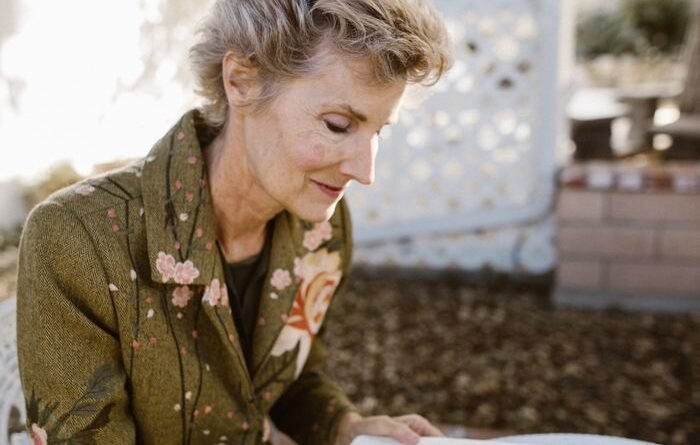tidbits of experience — senior woman writing in a notebook while sitting outside in a garden